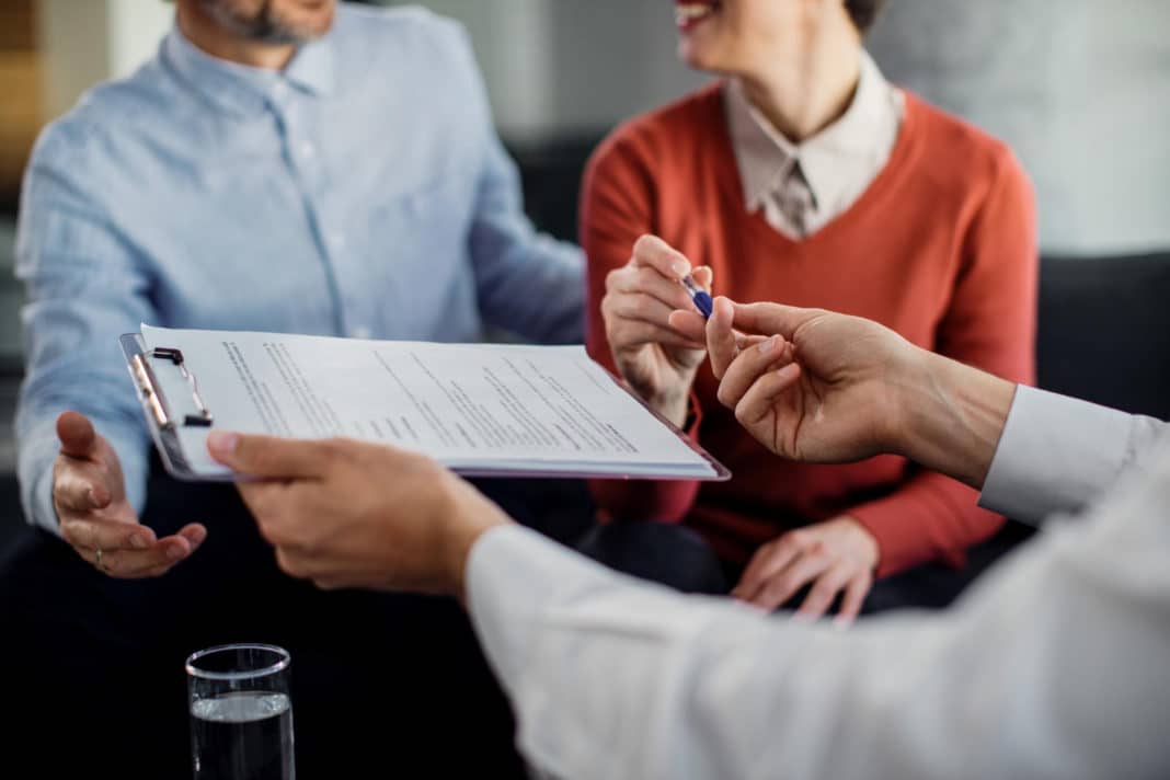 gros plan couple meconnaissable signant contrat conseiller financier