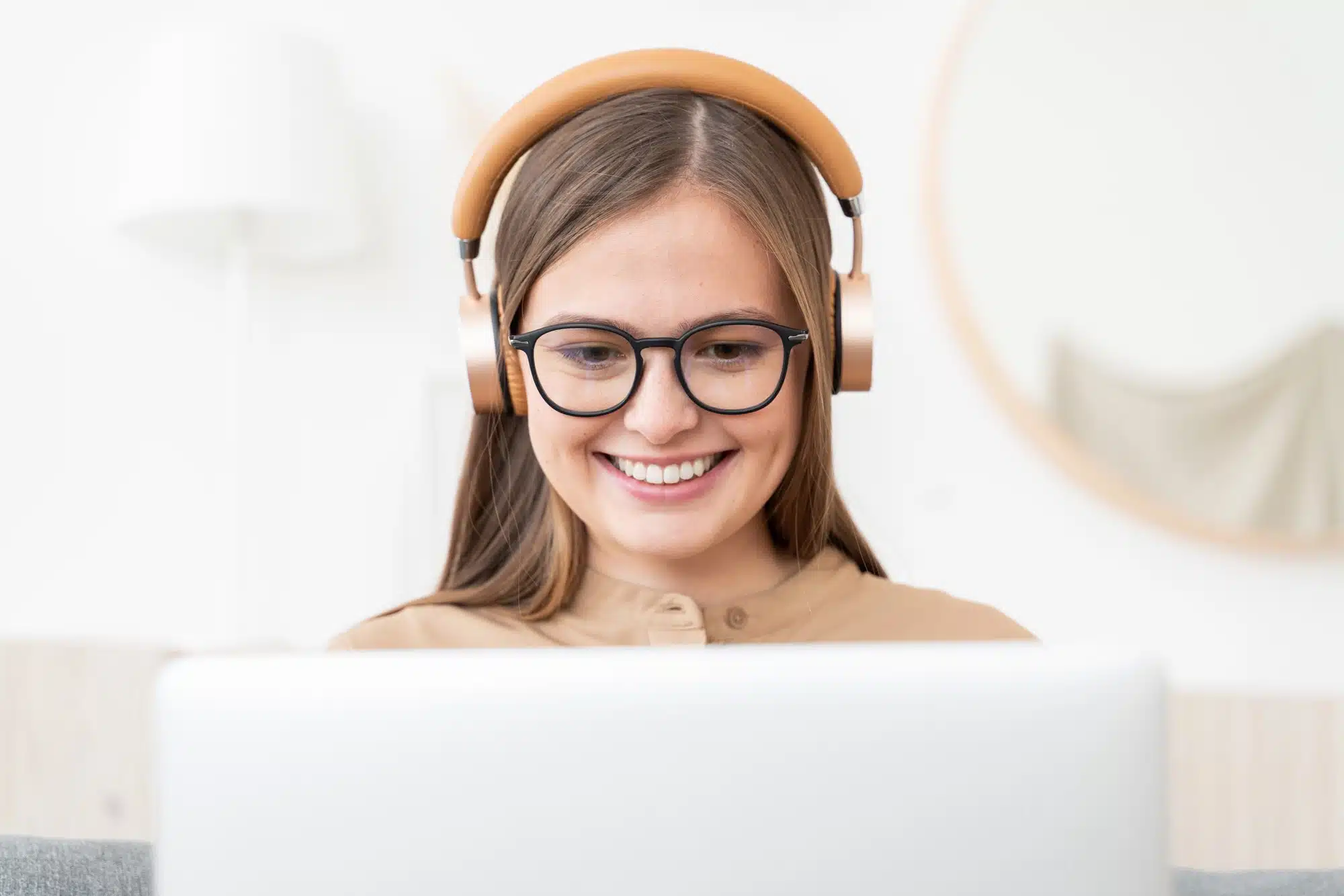 Laughing freelance girl spending time at home, working on laptop, listening to conference call