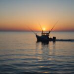 Bateau de pêche de loisir sur l'océan Atlantique au coucher du soleil